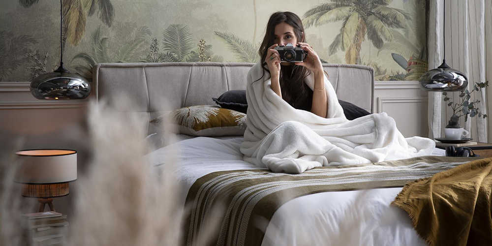 Femme sur un lit dans une chambre ambiance tropicale