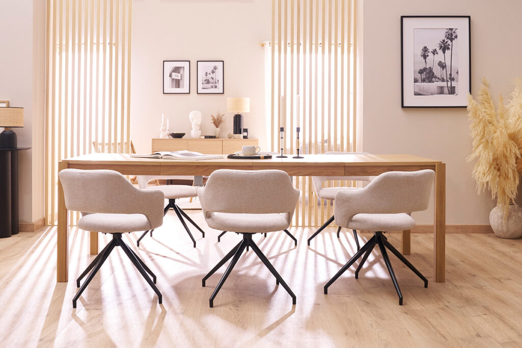 grande table à manger en bois clair avec chaises tissu et métal